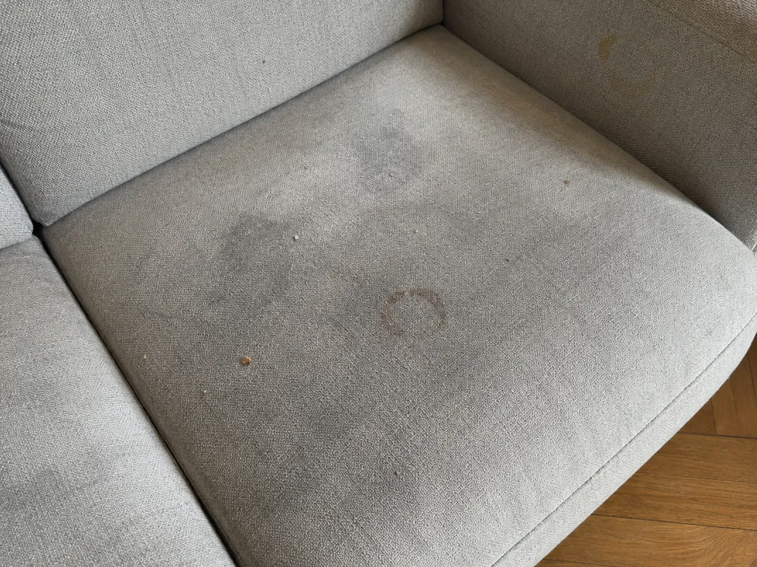 Avant nettoyage : Canapé 3 places en tissu gris, taches de café, auréoles et assises grisées par l'usage